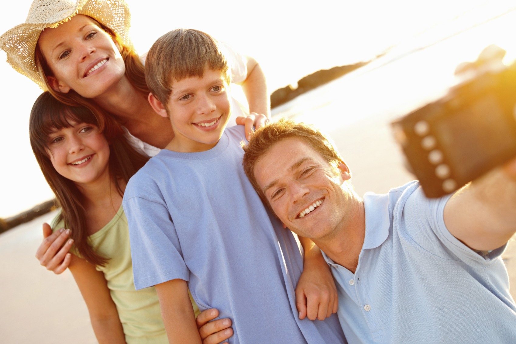 Happy family taking a self picture at the sea shore on a sunny d