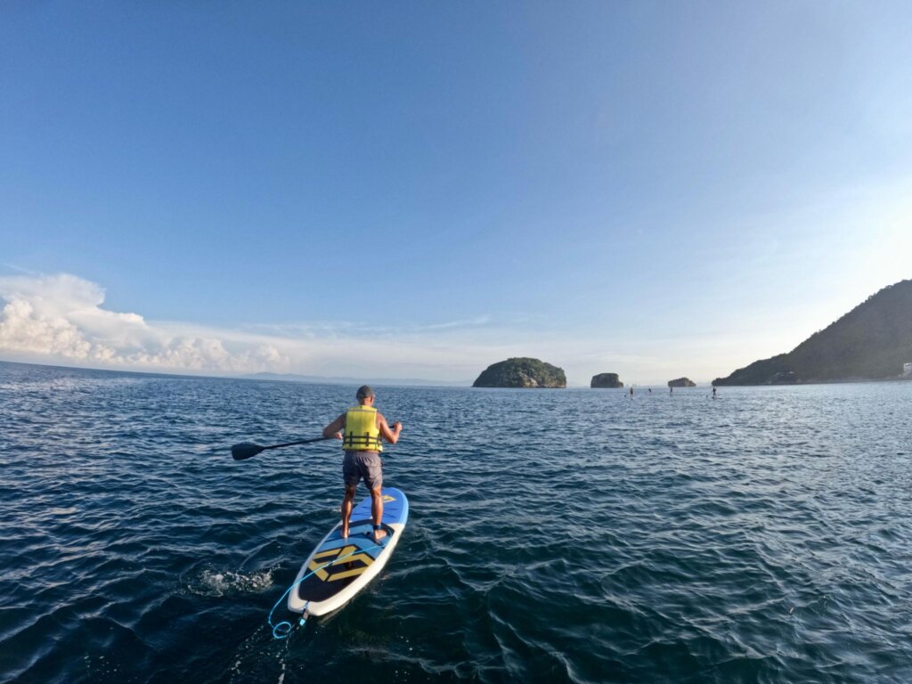 A guest paddleboarding in its way to Mismaloya Arches in Puerto Vallarta for a meditation experience.